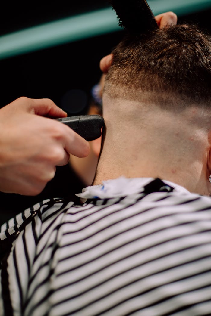 Close-up of a man's haircut in a Geneva barber shop, highlighting skilled hairstyling.
